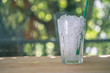 Glass of crushed ice with tube green