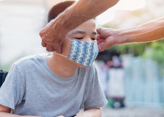 Special child on wheelchair wearing a protection mask,Against PM 2.5 air pollution and flu Covid 19 or Coronavirus, Stay at home to prevent the spread of the virus disease 2020,He being uncomfortable.