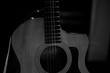 © Hennadii - A professional acoustic guitar stands on stage on a black background. Black and white photography