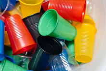 A Large Pile Of Multicolored Plastic Cups Scattered On The Floor. Pollution Of The Environment By Human Waste