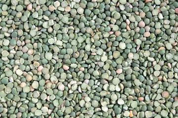 Food supplies. Crop of many dry green green peases grains on flat surface as background top view close up