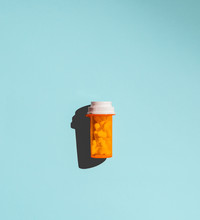 Pill Bottle Casting Shadow On Blue Background