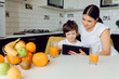 © Serhii - Happy family using a tablet pc in kitchen