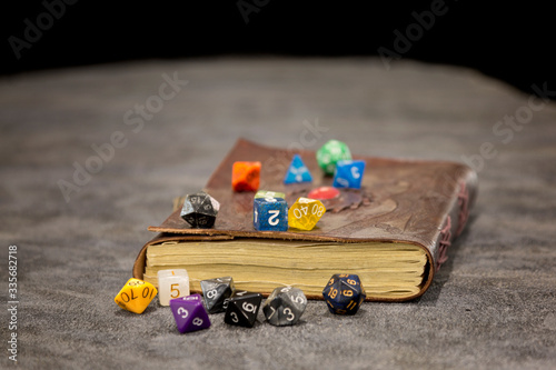 An old spell book with role playing dice piled around it.