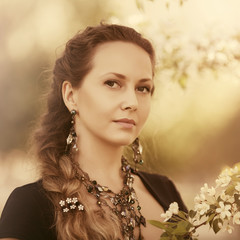 Happy beautiful fashion woman in a spring blooming garden