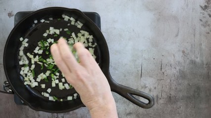 Wall Mural - Adding hopped Jalapeno to Sautéed Onions in a Cast Iron Pan