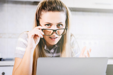 Wall Mural - Young woman in glasses near a laptop.