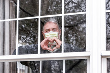 Man Wearing Mask Making Heart Symbol With Hands At The Window