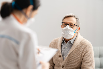 Wall Mural - Doctor and senior man wearing facemasks