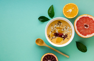 Wall Mural - Citrus smoothie bowl with grapefruit and orange on a blue background