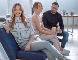 Poster - young business woman sitting in office lobby at coffee break