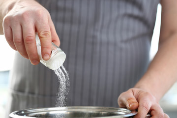 Male hand hold saltcellar salt soup cloceup concept aganist kithen background