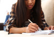 © H_Ko - Arm of black woman write story in notebook preparing for college