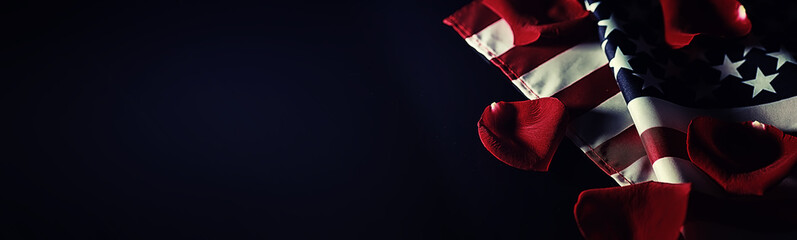 American flag and rose flower on the table. Symbol of the United States of America and red petals. Patriotism and memory.