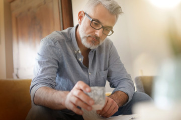 Wall Mural - Man at home sitting in sofa having hot coffee