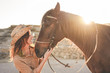 © DisobeyArt - Young farmer woman playing with her bitless horse in a sunny day inside corral ranch - Concept about love between people and animals - Focus on girl face