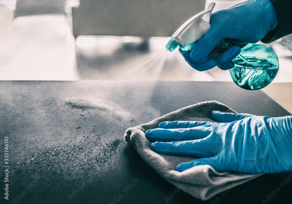 Surface sanitizing against COVID-19 outbreak. Home cleaning spraying antibacterial spray bottle disinfecting against coronavirus wearing nitrile gloves. Sanitize hospital surfaces prevention. - obrazy, fototapety, plakaty 