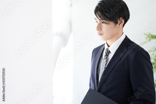 真剣な表情で窓の外を見る日本人男性ビジネスマン Stock Photo Adobe Stock