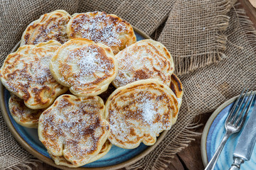 Fluffy homemade pancakes with apple dusted with icing sugar