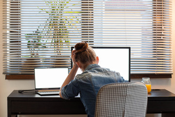 depressed woman working from home holding her head