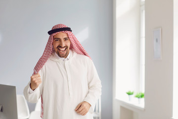 Wall Mural - Arab man stands in a white office.