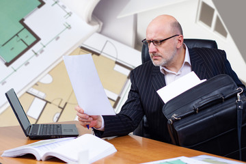 Aufkleber - Businessman is considering blueprints. Man in a business suit on background of construction drawings. Concept - inspector studies a house plan. Realtor is studying the layout. Man next to a laptop