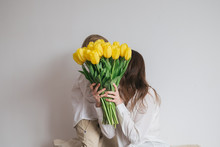 Boy Child Son Congratulates Mom With A Bouquet Of Yellow Tulips. Mother's Day, Women's Day. Birthday. Hug, Laugh, Happy.