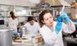 © JackF - Female chemist analyzing liquid in test flasks