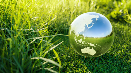 planet earth crystal ball on a green grass field environmental protection, ecology and crystal ball 