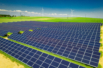 Wall Mural - Stunning solar panels, green field and blue sky, aerial view