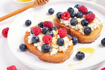 Wall Mural - Sandwiches with blueberries, raspberries and honey on toasts with curd cheese