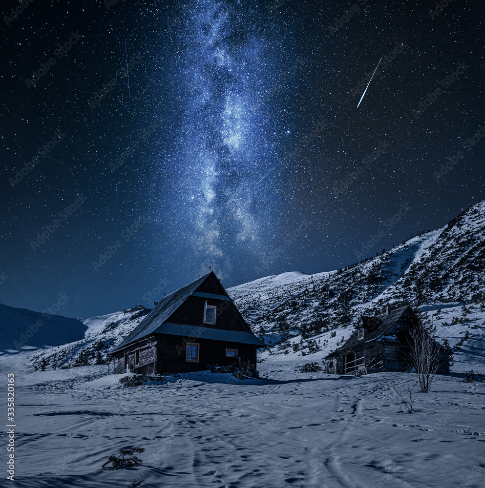 Milky way over wooden cottage in Gasienicowa valley at winter - obrazy, fototapety, plakaty 