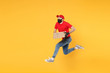 © ViDi Studio - Fun jumping delivery man in red cap t-shirt uniform sterile face mask gloves isolated on yellow background studio Guy employee courier Service quarantine pandemic coronavirus virus 2019-ncov concept.