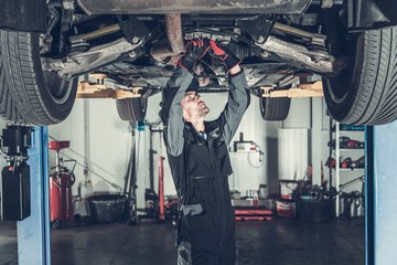 Mechanic Fixing Car on a Lift