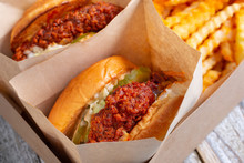 A View Of A Box Of Hot Chicken Sandwiches And Crinkle Cut French Fries, In A Restaurant Or Kitchen Setting.