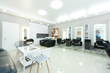 © Prostock-studio - Blurry barbershop interior with black armchairs and mirrors