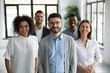 Leinwandbild Motiv Close up headshot portrait of three happy diverse businesspeople looking at camera. Different smiling employee standing behind of female and male company mentors. Leader of multi-ethnic team concept.