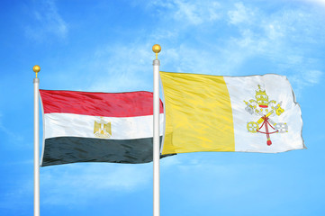 Egypt and Vatican two flags on flagpoles and blue cloudy sky