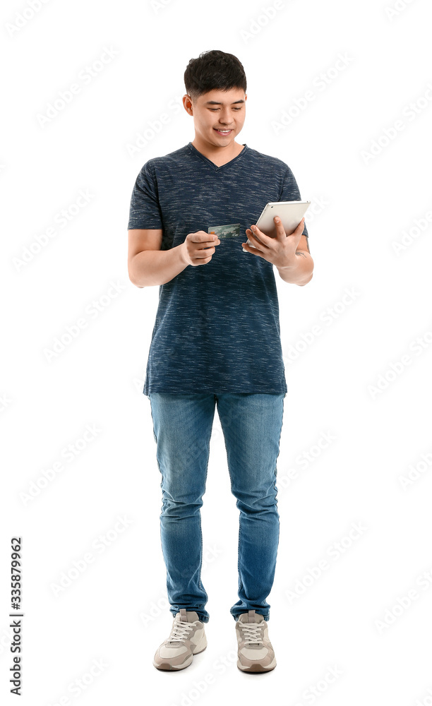 Asian man with credit card and tablet computer on white background