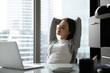 © fizkes - Happy young businesswoman sit at desk in office stretch in chair after finished computer work, smiling relaxed millennial female employee rest exercise at workplace, take break from job