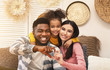 © Prostock-studio - Smiling millennial family on sofa at home