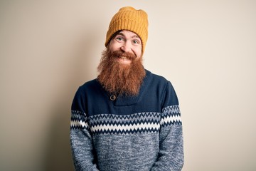 Sticker - Handsome Irish redhead man with beard wearing winter sweater and wool hat with a happy and cool smile on face. Lucky person.