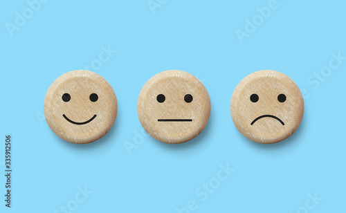 Wooden blocks with facial expressions negative, neutral and positive. Customer service experience and satisfaction survey concept . Feedback icons for client