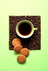 Wall Mural - Coffee composition of a Cup with coffee and coffee beans on a green background. Coffee mood.