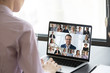 © fizkes - Multiracial people involved in group video call using modern tech videoconferencing application for study or business concept, view over businesswoman shoulder sitting at desk working with colleagues