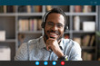 © fizkes - Head shot African man wear headset sit at desk look at cam use videocall conferencing app, pc screen view. Company consultant, teacher portrait, easy e-learn, distant communication with client concept