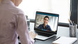 © fizkes - Indian girl communicate with friend on-line by video call, pc screen view over female shoulder. Mental health expert online therapy, colleagues work on common project use videoconferencing app concept