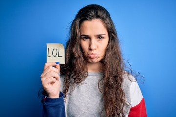 Sticker - Young beautiful woman with curly hair holding reminder paper with lol message with a confident expression on smart face thinking serious