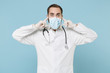 © ViDi Studio - Male doctor man in white medical gown sterile face mask gloves isolated on blue background. Epidemic pandemic spreading coronavirus 2019-ncov sars covid-19 flu virus concept. Cover ears with fingers.