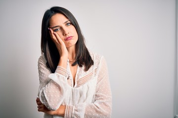 Wall Mural - Young brunette woman with blue eyes wearing casual t-shirt over isolated white background thinking looking tired and bored with depression problems with crossed arms.